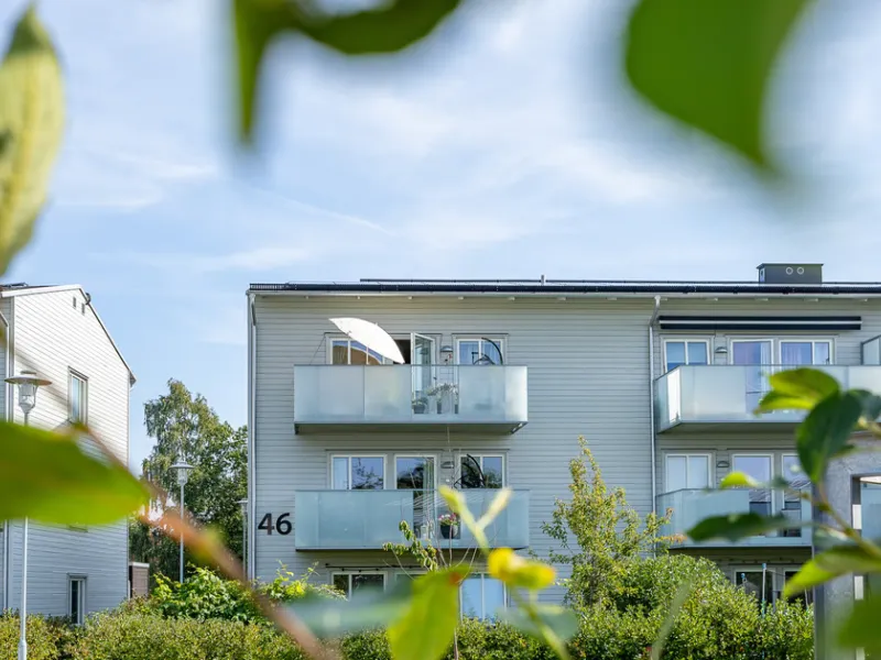 Gavelfyra högst upp i huset med balkong mot lummig poolgård